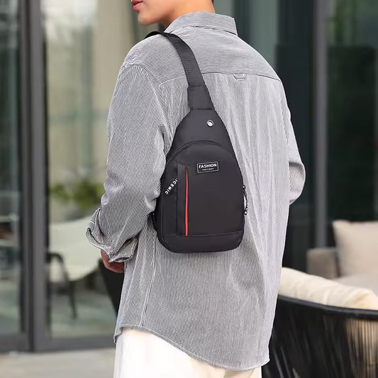 A person wears a black sling bag with red stripe and 'FASHION' label over a striped shirt, facing away.