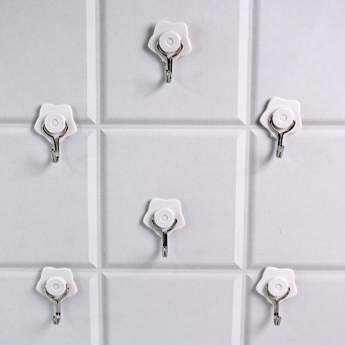 A yellow self-adhesive hook securely holding a towel in a modern bathroom.