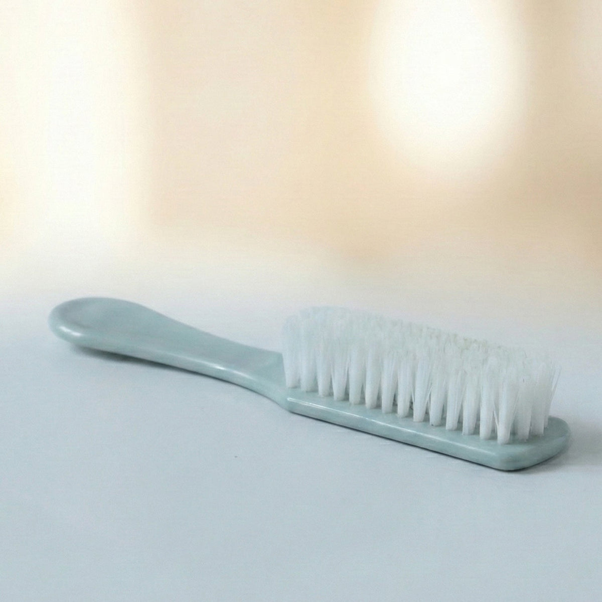 Handheld brush cleaning a shoe sole, demonstrating versatile utility