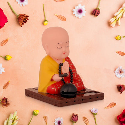 Solar Buddha statue with moving head and hand, ideal for car dashboards or office desks.