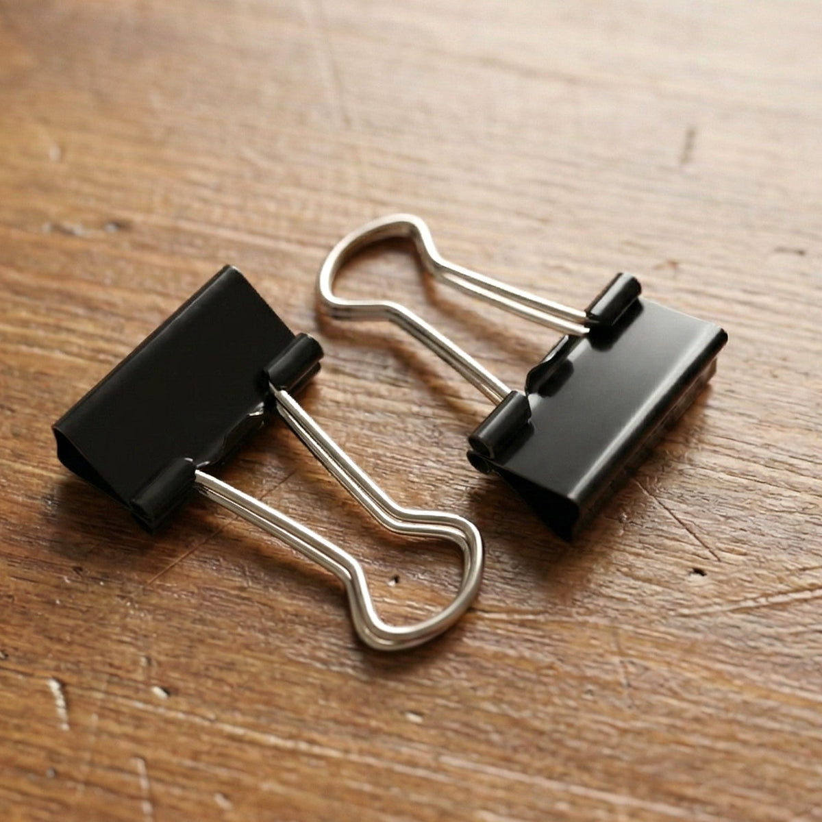 Black coated metal binder clip close-up showing spring mechanism