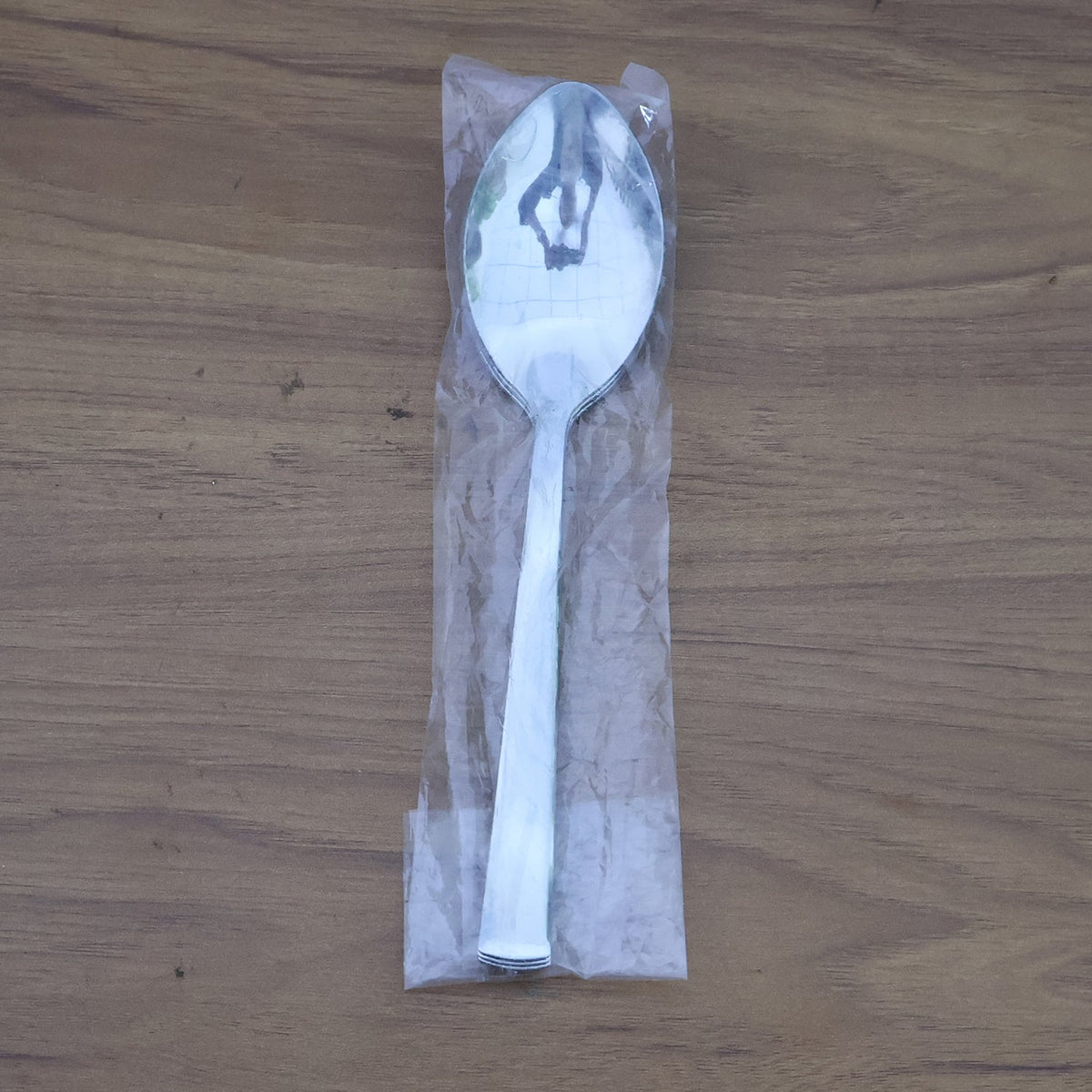 Stacked stainless steel dining spoons placed in a home kitchen setting