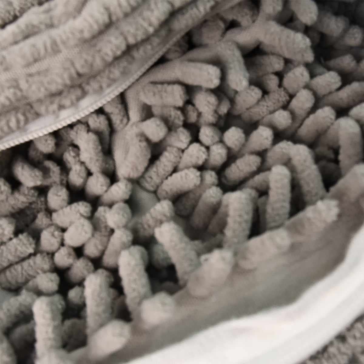 Reusable laundry bag holding a pair of sports shoes for washing